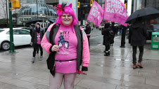 ピンク色のヘアスタイルで全身ピンク色でイベントに参加するボランティア女性